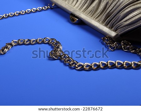 women bag with chain over bright blue background