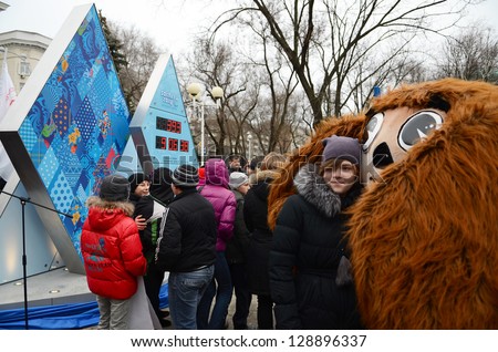 ROSTOV-ON-DON, RUSSIA - FEBRUARY 7:  Unidentified girl in an embrace with Olympic bear-start Olympic countdown clock time before the Olympic Winter Games 2014 in Sochi, February 7, 2013 in Rostov-on-Don, Russia
