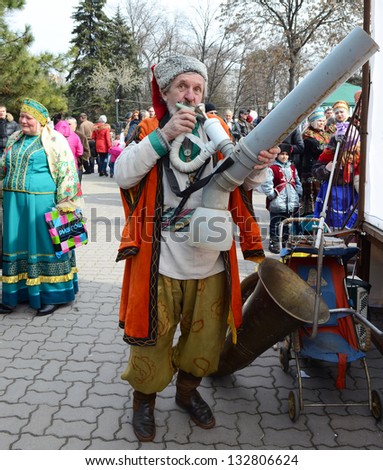 ROSTOV-ON-DON, RUSSIA - MARCH 17: Cossack plays on a makeshift instrument.The Cossack Maslenitsa - traditional celebration and national ski races around, March 17, 2013 in Rostov-on-Don, Russia