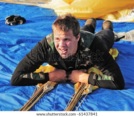 The young sportsman lays on the parachute for removal from it air