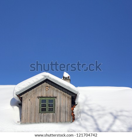 The old wooden roof covered with snow and blue sky