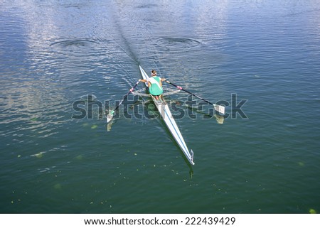Women Rower in a boat, rowing on the tranquil lake
