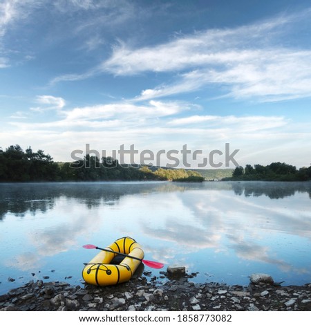 Yellow packraft rubber boat with red padle on a sunrise river. Packrafting. Active lifestile concept Stock fotó © 