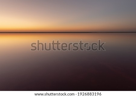 Tranquil minimalist landscape with smooth surface of the pink salt lake with calm water with horizon with clear sky in sunset time. Simple beautiful natural calm background ストックフォト © 