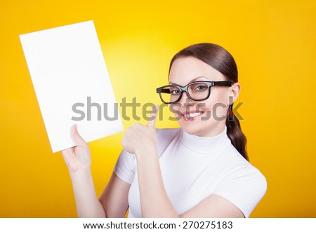 portrait of a woman with glasses on a yellow background. Business woman holding a poster