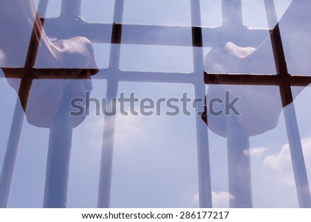 Prisoner holding bars in the jail. Double exposure