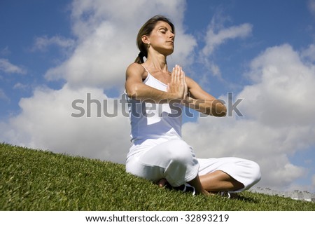 Pretty woman in white doing yoga outdoor