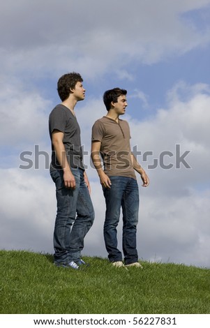 Two young men speaking and looking away