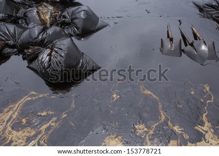 Dirty Sand beach with Spades and Plastic bags which contain crude oil from the clean up operation on oil spill accident on Ao Prao Beach at Samet island on July 2013 in Rayong, Thailand.