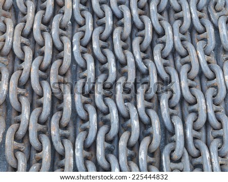 Many lines of used rusty heavy iron chain on the ground.