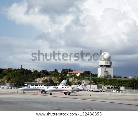 INCESS JULIANA AIRPORT, ST MAARTEN - NOVEMBER 9: Private jets and traffic control tower in Princess Juliana Airport on November 9, 2012. Airport  serves the Dutch part of the island of Saint Martin.