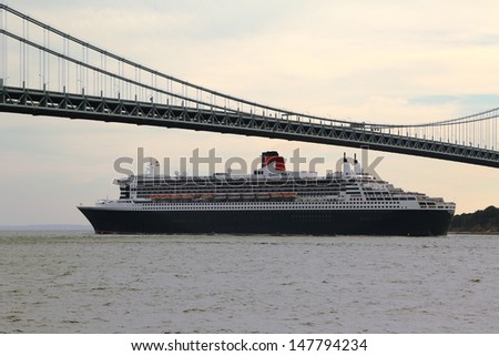 NEW YORK CITY - JULY 27: Queen Mary 2 cruise ship in New York Harbor under Verrazano Bridge heading for Transatlantic Crossing  from New York to  Southampton on July 27, 2013