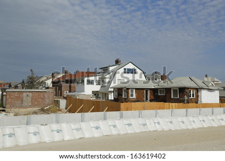 FAR ROCKAWAY, NY - OCTOBER 22: Damaged beach house in devastated area one year after Hurricane Sandy on October 22, 2013 in Far Rockaway, NY. Notice protective barrier build to prevent flooding