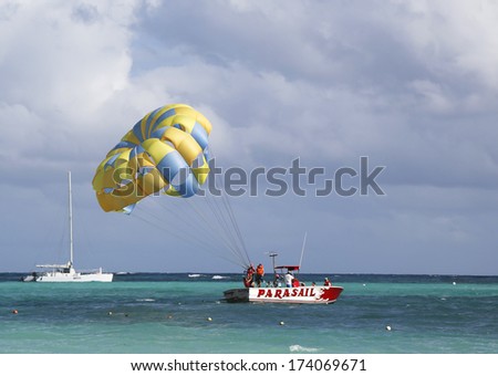 PUNTA CANA, DOMINICAN REPUBLIC - DECEMBER 31: Parasailing in a blue sky in Punta Cana on December 31, 2013. Parasailing is a popular recreational activity among tourists in Dominican Republic