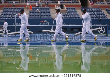NEW YORK -SEPTEMBER 6: US Open cleaning crew drying tennis court after rain delay at Arthur Ashe Stadium at Billie Jean King National Tennis Center on September 6, 2014 in Flushing, NY