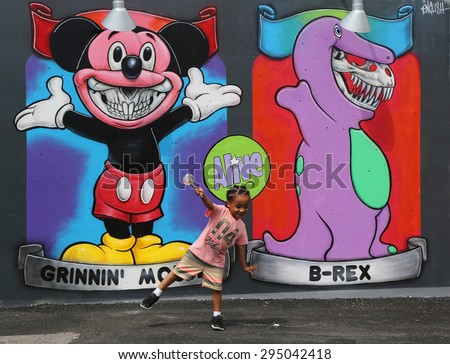 NEW YORK - JUNE 30, 2015: Unidentified child in the front of the mural art at the new street art attraction Coney Art Walls at Coney Island section in Brooklyn