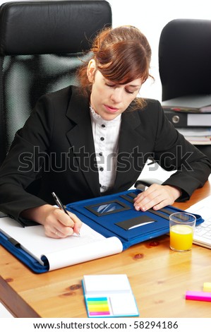Pretty red-haired business lady or student working at a desk