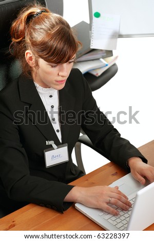Pretty redhaired business lady or student working with a laptop, with a badge \
