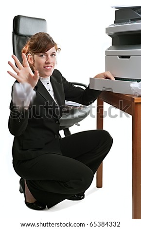 Pretty business lady or student clearing a printer paper jam and throwing jammed paper towards the viewer.