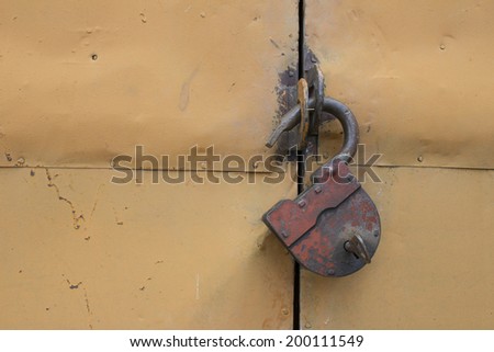 The old hinged granary rusty lock on orange doors