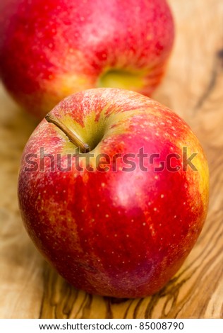 two apples on wooden table in garden