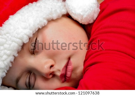 child dressed as Santa Claus sleeping in bed