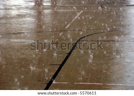 Outdoor basketball court with no activity due to heavy rain.