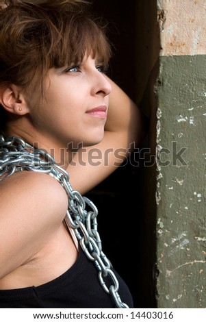 Portrait of pretty red-haired girl with a metal chain on the neck .
