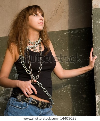 Portrait of pretty red-haired girl with a metal chain on the neck and shoulder .