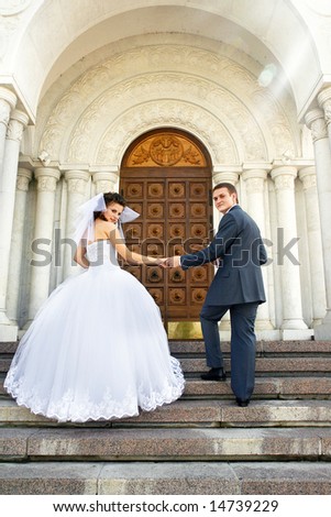 Bride with the groom near the entrance to the church