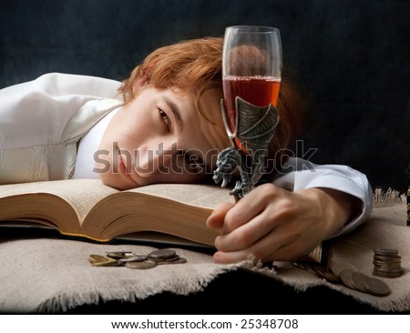 Portrait of handsome man with the glass of wine and old books.