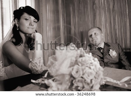 Portrait of a newlywed couple with the bride\'s bouquet. Focus point on the bride.