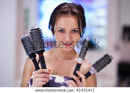 Pretty girl with the hair brushes. Blurred colorful background.
