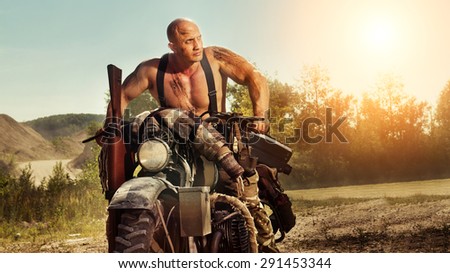 Muscular bald biker on the autumn background. Instagram-like toning.