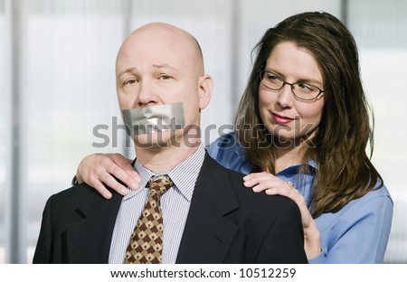 Portrait of Business team - the man is being muzzled with duct tape