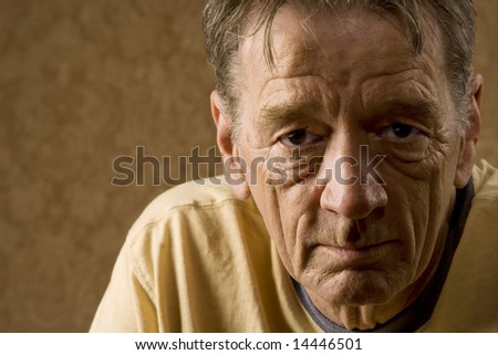 Senior Man Against a Gold Background with a Stern Expression
