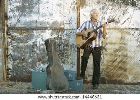 Handsome man playing an old acoustic guitar