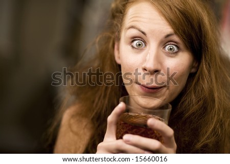 Woman with big eyes and hair sipping cocktail