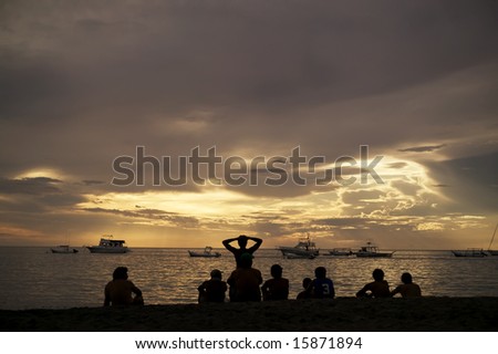 Costa Rica sunset with Boats and silhouettes of people on beach