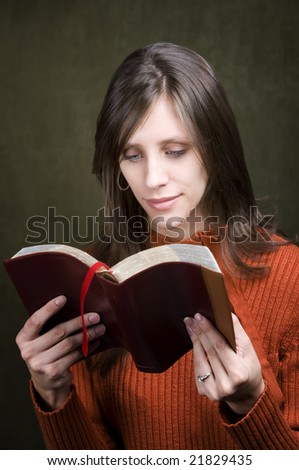 Pretty woman in orange sweater with Bible