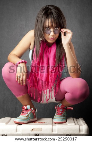 Pretty young mixed race woman crouched on a cargo bax