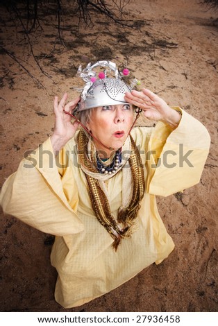 Crazy woman wearing a colander helmet waiting for a spaceship