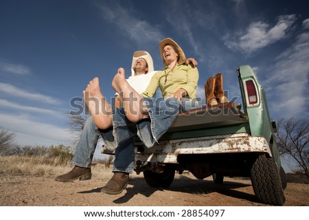 Portrait of Cowboy and woman on pickup truck bed