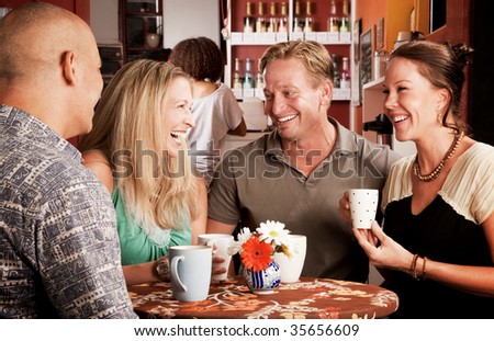 Four adult friends meeting in a coffee house