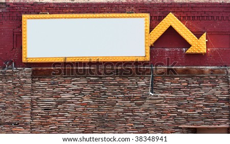 Blank sign surrounded with yellow lights on brick building