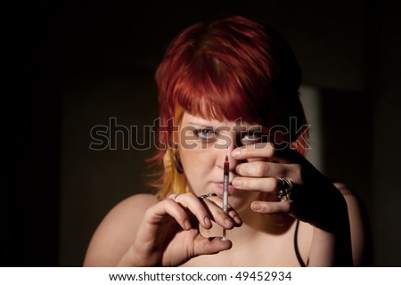 Heroin addict clearing the end of a hypodermic needle