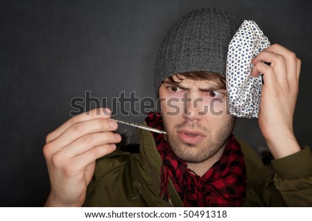 Sick man with thermometer and ice pack on head