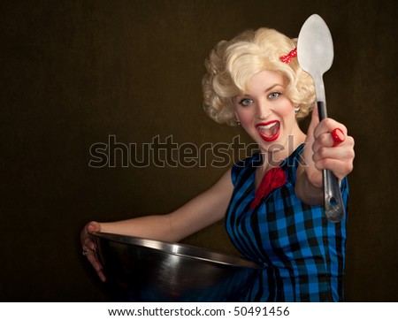 Pretty retro blonde woman in vintage 50s dress with bowl and spoon