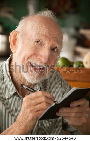 Senior man at home with checkbook