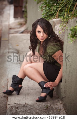 Pretty latina Woman Sitting on Step Outdoors
